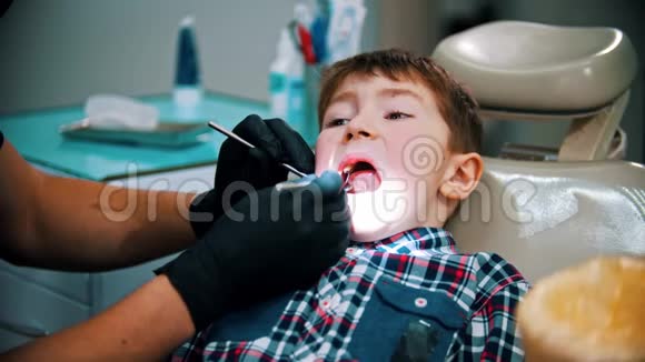 一个有压力的小男孩牙齿受损在现代牙科治疗口腔检查视频的预览图