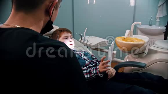 一个在牙科治疗的小男孩拿着镜子视频的预览图