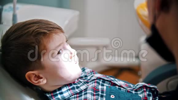 牙医在牙科中检查一个男孩的嘴视频的预览图