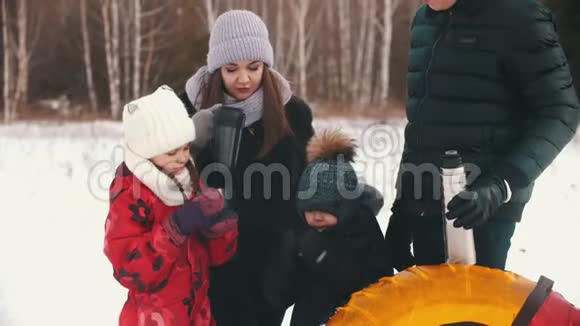 一家人在冬季森林附近喝热饮料视频的预览图