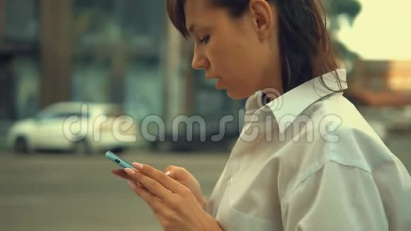 女商人在户外社交媒体上滚动新闻视频的预览图