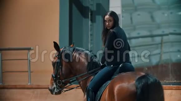 一个骑马者坐在马背上握着她的缰绳视频的预览图