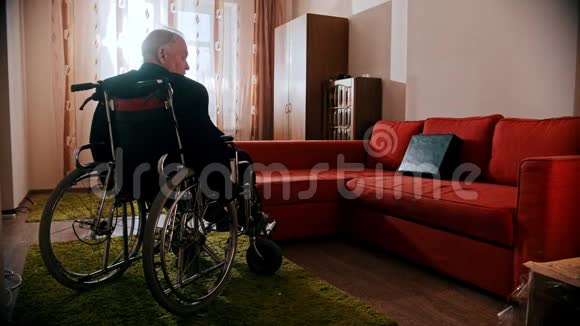 年迈的祖父悲伤的祖父正坐着轮椅在房间里转悠视频的预览图