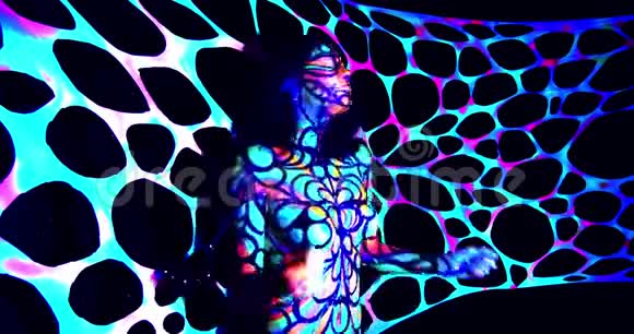 一位年轻女子在跳舞和移动她的头上身上有五颜六色的发光体艺术视频的预览图