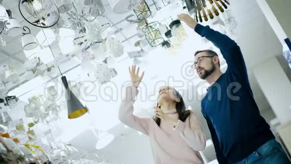 年轻夫妇在电器商店里选择一盏灯视频的预览图