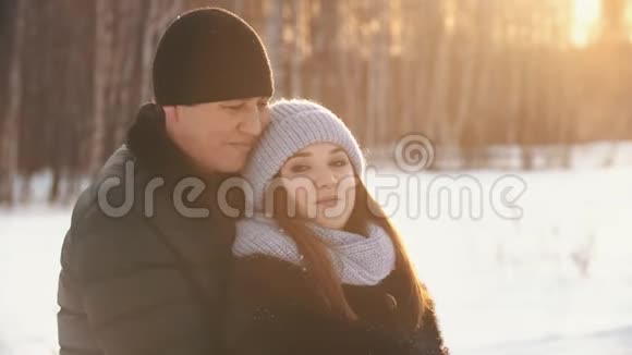 夕阳下的冬林背景下一对情侣拥抱亲吻视频的预览图