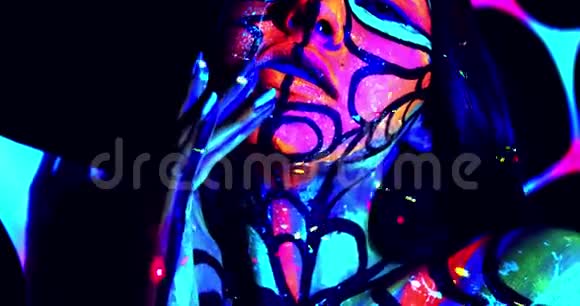 有线条和图案的彩色身体艺术的年轻女子紫外线4k视频的预览图