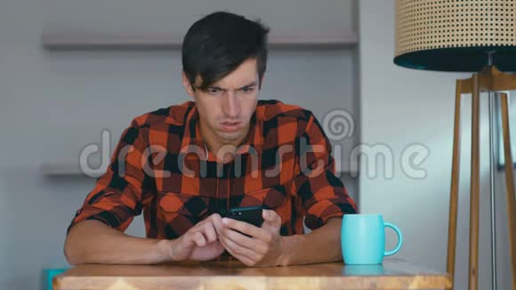 愤怒的男人在家里用手机沮丧的企业家对他在智能手机上读到的信息感到愤怒视频的预览图