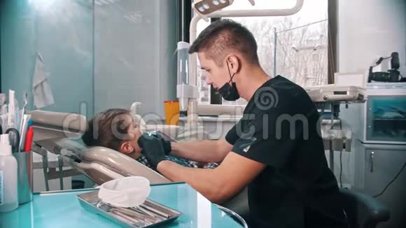 一个压力很大的小男孩在现代的牙科手术中完成了他的牙齿视频的预览图
