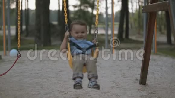 快乐的宝宝骑在秋千上视频的预览图