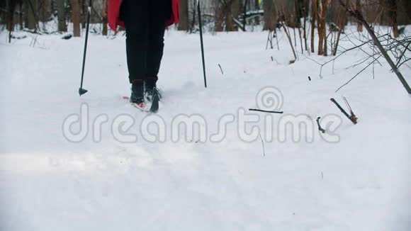 一个女人试图在树林里滑雪停止移动从滑雪场上脱下靴子视频的预览图