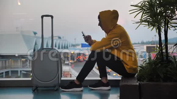 戴头巾的旅客剪影行李在机场候机楼等候旅客使用视频的预览图