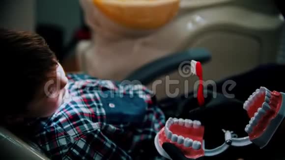 一个正在牙科治疗的小男孩在谈论如何正确刷牙视频的预览图