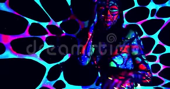 年轻女子在黑暗中跳舞发光的彩色身体艺术4K视频的预览图