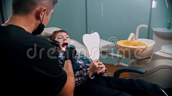 一个小男孩在牙科诊所里做牙齿那个男孩照镜子视频的预览图