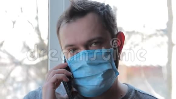 冠状病毒家里男人戴着防护面罩接受冠状病毒检疫的男性戴防护面罩特写视频的预览图