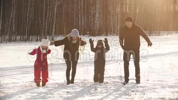 日落时分一个幸福的家庭牵着手在冬林附近跳跃视频的预览图