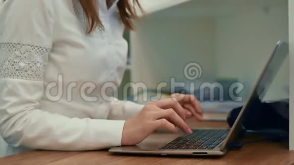 商务女性在办公桌上使用笔记本电脑女性在笔记本键盘上打字学习工作关闭视野视频的预览图