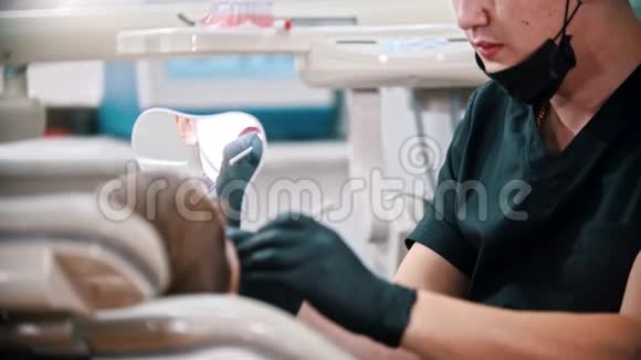年轻人牙医检查一个男孩的嘴视频的预览图