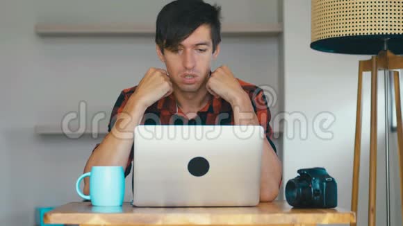 工作过度的男性摄影师自由职业者厌倦了在笔记本电脑上工作感到沮丧和沮丧创意创意视频的预览图