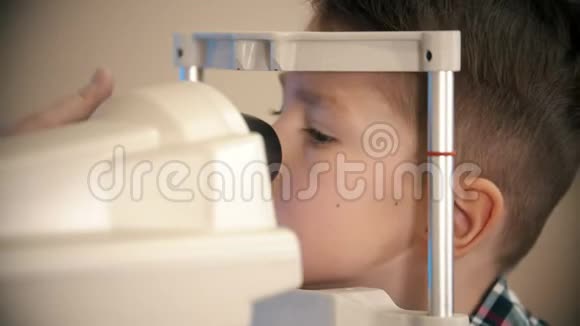 一个在眼科诊所接受治疗的小男孩透过这个装置的镜片视频的预览图