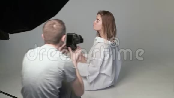 男摄影师拍摄少女白种人假扮照片的后台视频的预览图