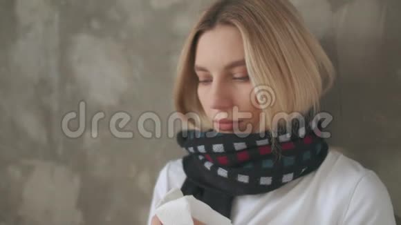 一个生病的女孩看着温度计吹着鼻子抓感冒女孩用纸手帕擦鼻涕样子视频的预览图