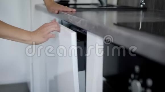幸福的年轻女性在家中用洗碗机摆放盘子视频的预览图