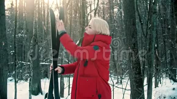 一个穿着红色羽绒服的年轻女子从滑雪场上抖落了雪视频的预览图