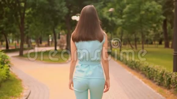后景近景走在街上的女人面对镜头城市公园夏季户外视频的预览图