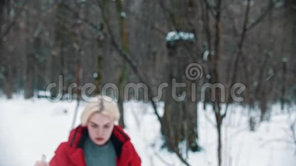 一个疲惫的金发女人在树林里滑雪视频的预览图