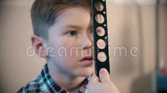 一个在眼科诊所接受治疗的小男孩一位医生用不同的方法检查一个小男孩的视力视频的预览图