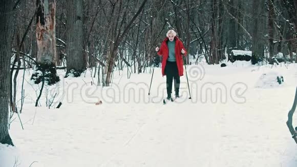一个年轻的金发女人在树林里滑雪视频的预览图