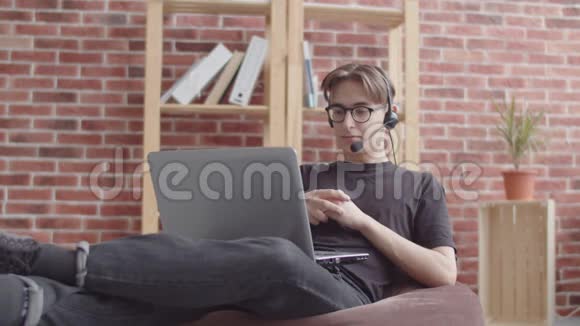 这家伙在笔记本电脑上在线咨询看着相机学生在呼叫中心做接线员视频的预览图