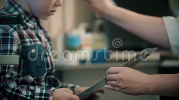 眼科诊所的治疗一个小男孩在读信医生在男孩眼前换镜片视频的预览图