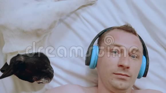 合拢面部男性与狗享受音乐视频的预览图