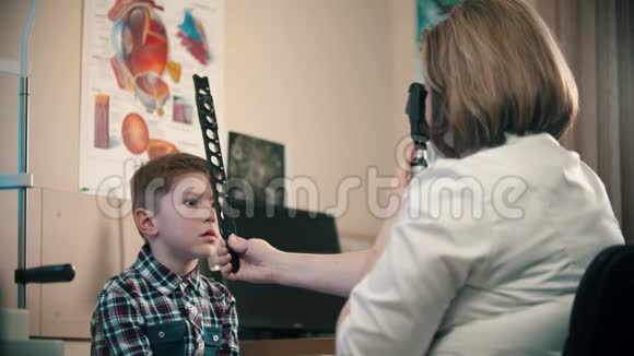 一个在眼科诊所接受治疗的小男孩一位女医生用视频的预览图