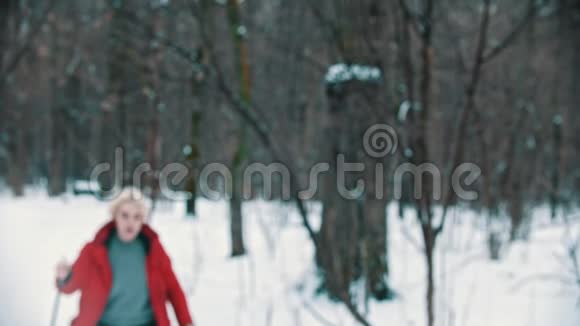 一位年轻的金发女子在树林里滑雪迷路了她试图找到一条路视频的预览图