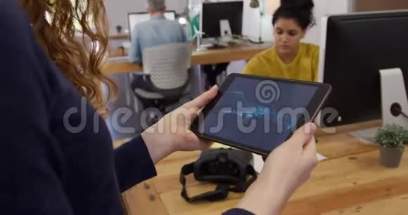 高加索女人在创意办公室里拿着平板电脑视频的预览图