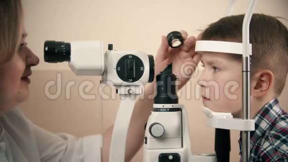 一个正在眼科诊所接受治疗的男孩一位女医生通过检查一个特殊的大男孩视力视频的预览图