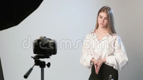 美女博主戴着蓝色手套站在镜头前录制视频视频的预览图