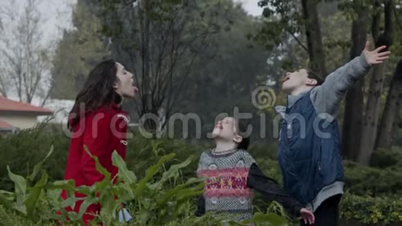 三个孩子站着慢悠悠地享受着倾盆大雨视频的预览图