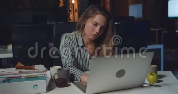 疲惫的女商人在夜间办公室的工作场所睡着的肖像精疲力竭的女雇员在睡觉时视频的预览图