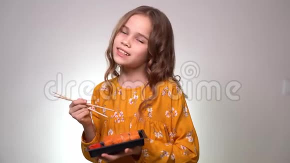 一个十几岁的女孩拿着一个有面包卷和棍子的盒子视频的预览图