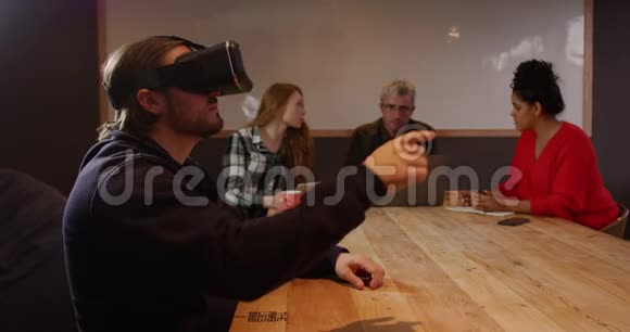 男士戴着VR耳机同事在创意办公室工作视频的预览图