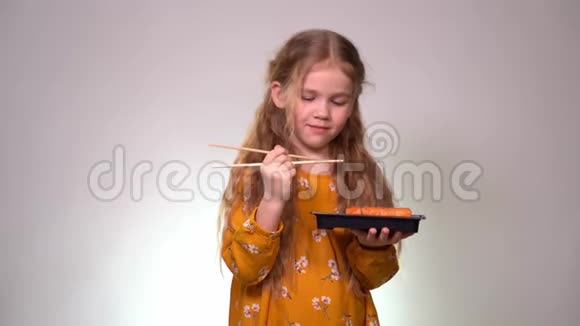 小女孩舔寿司棒和保持盒卷视频的预览图