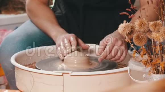 陶工师傅在车间的陶工车轮上用粘土工作视频的预览图