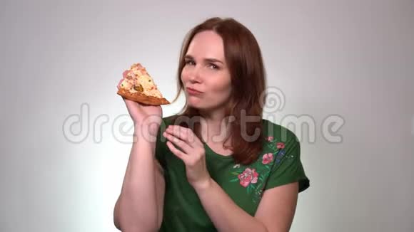 一个棕色头发的女人拿着一块比萨饼笑视频的预览图