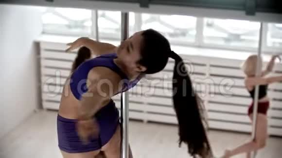 四个女人在训练室的舞杆上旋转视频的预览图