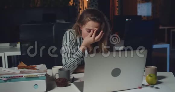 疲惫的年轻女商人坐在办公桌前按摩前额以集中精神女办公室工作人员视频的预览图